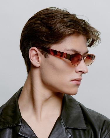 Lysebrun metal A.Kjærbede solbriller, med hængsler og mønstret stel fra siden på herre