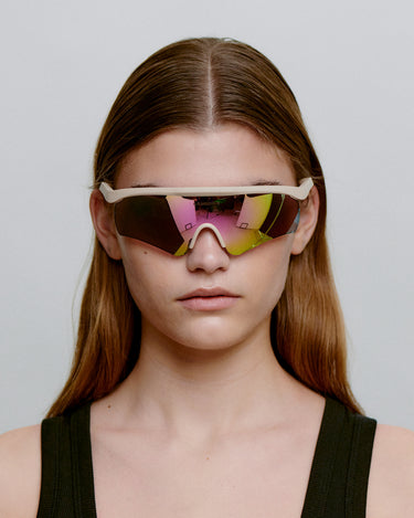 Beige løbe solbriller med farvet glas, set foran på dame